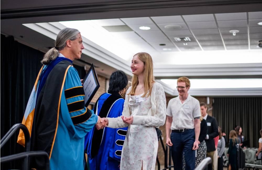 Student shaking hand with faculty 2